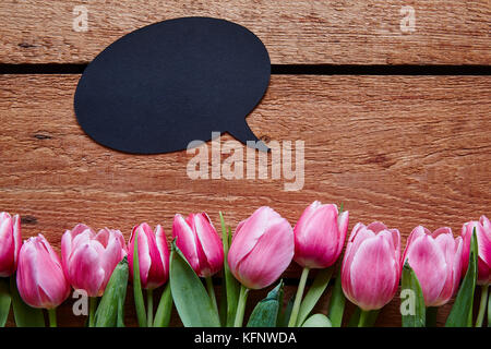 Messaggio di primavera discorso bolla e tulipani freschi su legno Foto Stock