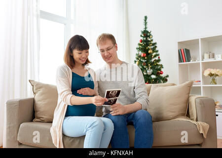 Coppia felice con immagini a ultrasuoni a natale Foto Stock