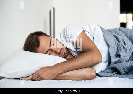 Uomo dorme nel letto Foto Stock