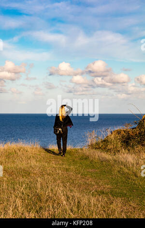 Una donna guarda fuori dalla scogliera cime oltre l'estuario del Tamigi a bishopstone, herne bay, Kent Foto Stock