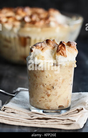 In casa budino di banana con meringa realizzato da zero su un rustico sfondo scuro. estrema profondità di campo con il fuoco selettivo. Foto Stock