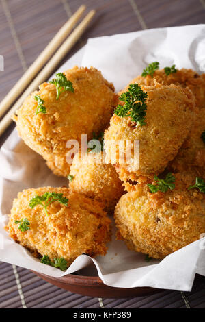 Crocchette di patate, o korokke giapponese, cucinato da purè di patate con carne macinata in un recipiente verticale. Foto Stock