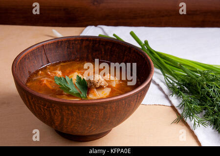 Borsch - tradizionale ucraino e russo rosso barbabietola zuppa di barbabietole rosse in vaso di creta. erbe - aneto, il cipollotto, prezzemolo intorno alla piastra. ukraini Foto Stock