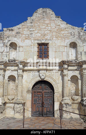 Primo piano della parte anteriore ingresso alla cappella della missione di alamo contro un luminoso cielo blu nel centro cittadino di San Antonio, Texas Foto Stock