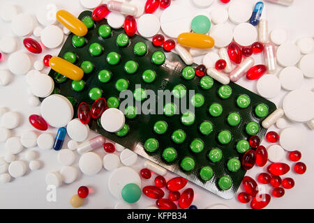 Cumulo di medicina compresse e pillole di colori diversi in blister su sfondo bianco. Copia dello spazio. Settore sanitario o medicina concetto di dipendenza Foto Stock