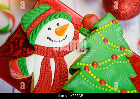 Festa di Natale cookie e il nuovo anno a forma di albero di natale, pupazzo di neve sul tavolo di legno sfondo Foto Stock