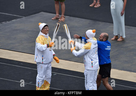 Atene, Grecia, 31 ottobre 2017. Il pattinatore di velocità in pensione coreano Kim Ki-hoon (L) consegna la fiamma olimpica al campione greco di sci Ioannis Proios (R) durante la cerimonia di consegna della fiamma olimpica per le Olimpiadi invernali di PyeongChang 2018 allo stadio Panathenaic di Atene, in Grecia. Crediti: Nicolas Koutsokostas/Alamy Live News. Foto Stock