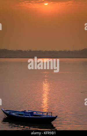 Una barca è galleggiante sul fiume Gange al momento del sorgere del sole in varanasi,l'india. Foto Stock