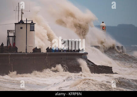 Onde infrangersi contro la parete del porto durante la tempesta Brian a Porthcawl, nel Galles del Sud. Il Met Office hanno rilasciato un giallo allarme meteo per vento e ha Foto Stock