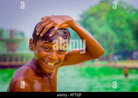 Delhi, India - 16 settembre 2017: ritratto di un massimo di unidentified sorridente ragazzo indiano, toccando la sua testa con la mano e guardando la telecamera, a Delhi Foto Stock