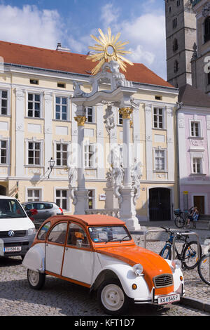 Un classico di Citroën 2CV auto di fronte all'Dreifaltigkeitssäule (Colonna della Santa Trinità) in Stein an der Donau, Sito Patrimonio Mondiale dell'UNESCO, Austria inferiore Foto Stock