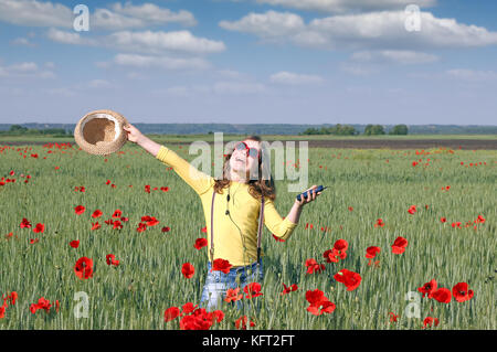 Felice bambina ascoltando la musica sul telefono cellulare in Prato Foto Stock