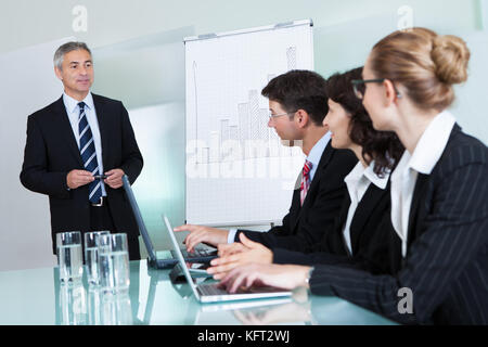 Vista ritagliata immagine di una fila di imprenditori lavora su laptop e tablet durante una presentazione o riunione Foto Stock