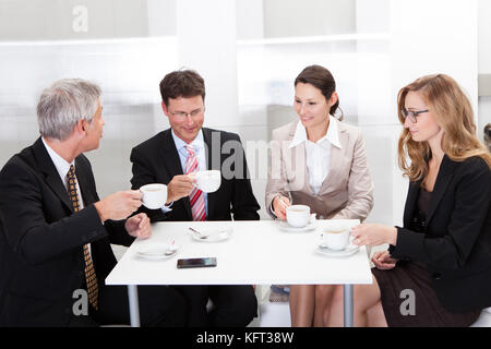 Colleghi di lavoro rilassante in un caffè o avente una riunione improvvisata nella caffetteria Foto Stock