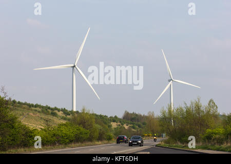 Due turbine eoliche che generano energia rinnovabile visto sopra una strada nel south yorkshire, Regno Unito Foto Stock