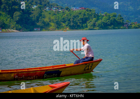 Pokhara, nepal - Novembre 04, 2017: close up dell'uomo paddling il giallo barca al lago Begnas in pokhara, Nepal Foto Stock