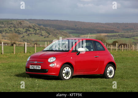 Rosso brillante Fiat 500 raffigurata sul South Downs a Chichester, West Sussex, Regno Unito. Foto Stock