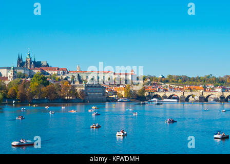 Pedalò e barche sul fiume Moldava, davanti a Mala Strana e Hrad castle hill, Praga, Repubblica Ceca Foto Stock