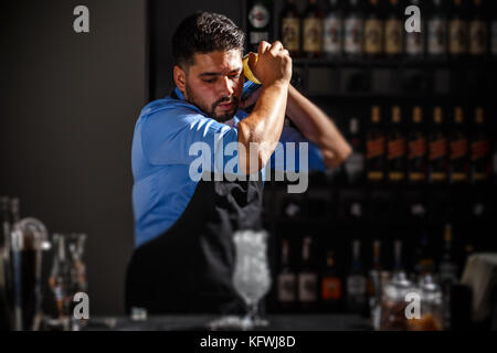 La barista scuote e miscelazione di cocktail alcolici Foto Stock