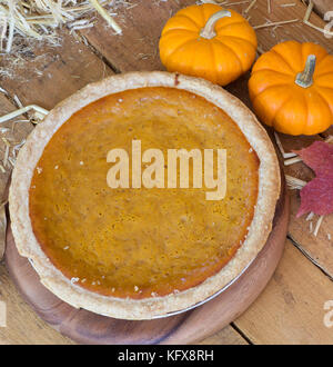 Tutta la torta di zucca su una superficie in legno Foto Stock