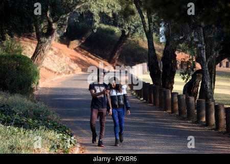 Coppia in cerca di un telefono cellulare mentre camminare per strada Foto Stock