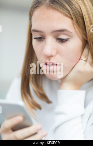 Ragazza adolescente di essere vittima di bullismo mediante messaggio di testo Foto Stock