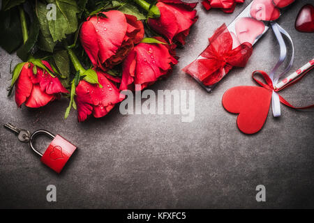 Il giorno di san valentino sfondo con abbastanza rose rosse mazzo, cuore, dono di candele, serratura e chiave, vista dall'alto, di confine Foto Stock