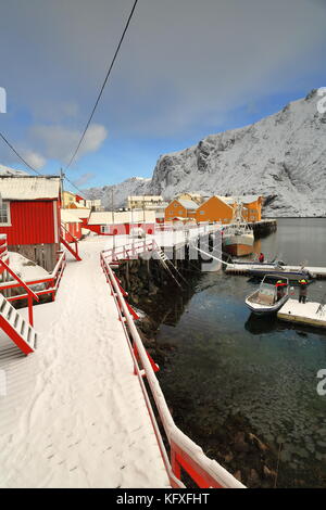 N.e.-reparti vista sulla coperta di neve del porto con ormeggi flottante-rorbuer legno-pescatori di nusfjord villaggio di pescatori di bottelvika-bay e mount n Foto Stock