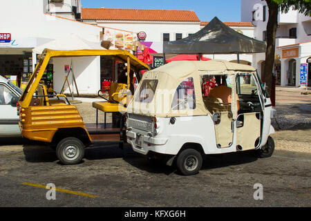 Piccolo Tuk Tuks parcheggiato in attesa per una tariffa nella parte superiore della striscia in Albuferia in Portogallo Foto Stock