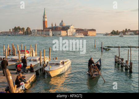 Gondole ormeggiate presso Riva degli Schiavoni a San Marco, Venezia, Italia. La laguna veneta e l'isola di San Giorgio maggiore sullo sfondo. Foto Stock