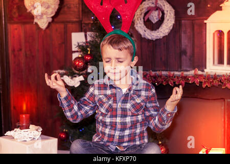 Giovane ragazzo in attesa di santa claus seduta sul tavolo Foto Stock