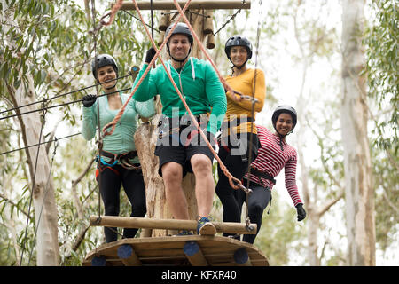 Happy amici ottenere pronto per la zip line a park in una giornata di sole Foto Stock