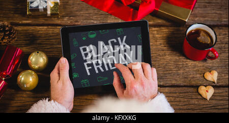 Venerdì nero con verde Natale icone contro babbo natale con tavoletta digitale Foto Stock