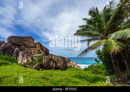 Escursioni di un sentiero nel deserto a mighty rosse rocce di granito nel lussureggiante verde erba ad anse songe, la digue, Seicelle Foto Stock