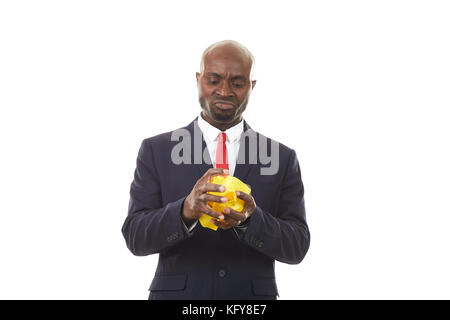 Ritratto di un uomo d'affari africano stressato documento crumpling Foto Stock