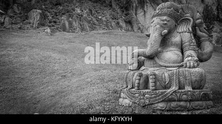 Ganesha statua, in pietra, con un bellissimo giardino con vista sulle montagne in background Foto Stock