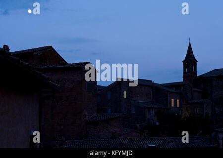 La luna sorge sopra il quartiere medievale nella cittadina umbra di Orvieto, Italia. Foto Stock