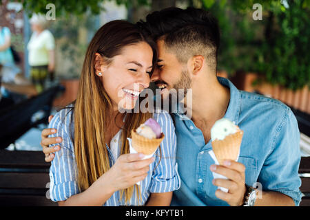 Felice coppia avente data e mangiare il gelato Foto Stock