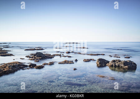 Le rocce in mare, una lunga esposizione fotografia, alta chiave. Castiglioncello, Toscana, Italia Foto Stock