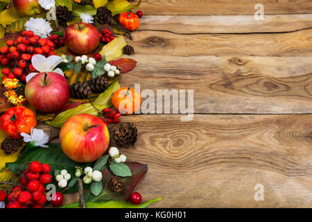 Ringraziamento o messaggio di saluto autunno sfondo con zucche, mele, rosso e bacche bianche sulla tavola in legno rustico, spazio di copia Foto Stock