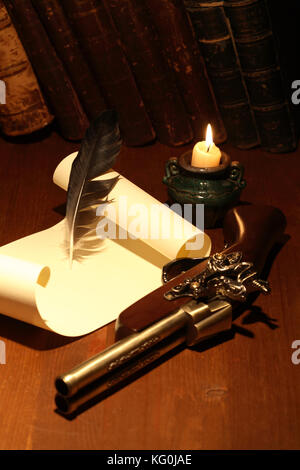 Pistola antica vicino a scorrere e il supporto sulla superficie di legno con illuminazione candela Foto Stock