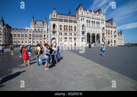 Ungheria, Budapest, Parlamento ungherese edificio dal Kossuth Lajos Square, gruppo di turisti in gita turistica Foto Stock