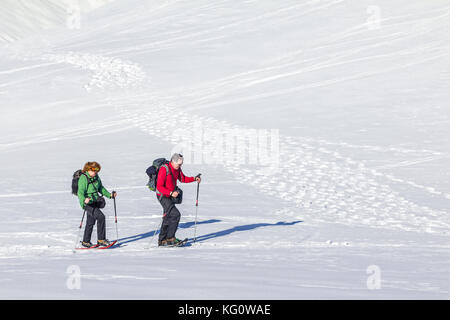 Coppia senior è escursioni con racchette da neve in inverno alpino montagne. La Baviera, Germania. Foto Stock