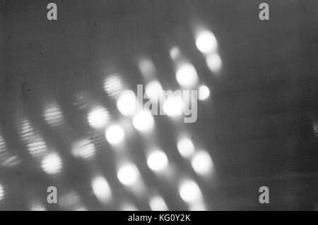 Punti di luce riflessa nella parete di una immagine in bianco e nero Foto Stock