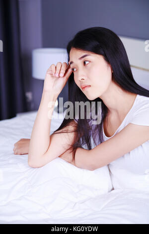 Donna preoccupati pensando a letto in camera da letto Foto Stock