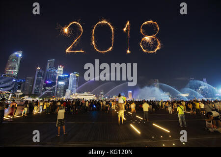 Singapore - agosto 19, 2017 : 2018 felice anno nuovo fuochi d' artificio sparkle con i turisti a marina bay sands anteriore in Singapore Foto Stock