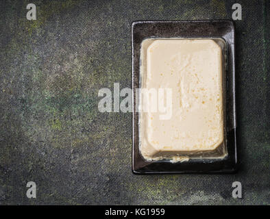 Tofu scuro su sfondo rustico, vista dall'alto, il luogo per il testo Foto Stock