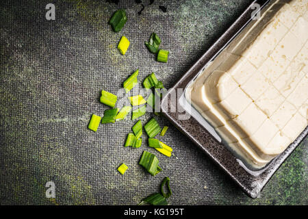 Tagliate a dadini di tofu delicato su sfondo rustico, vista dall'alto, close up Foto Stock