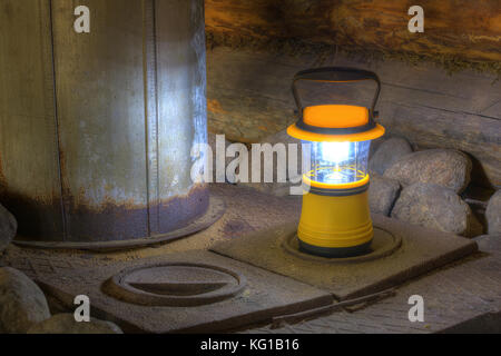 Luminosa lanterna a mano permanente sulla stufa vicino al camino Foto Stock