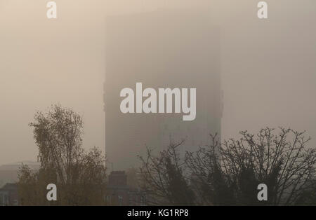 London Borough of Merton, Regno Unito. 3 novembre 2017. Una fitta banca di nebbia si avvicina a Morden quando inizia l'ora di punta, coprendo l'edificio del centro amministrativo del London Borough of Merton. Credit: Malcolm Park/Alamy Live News. Foto Stock